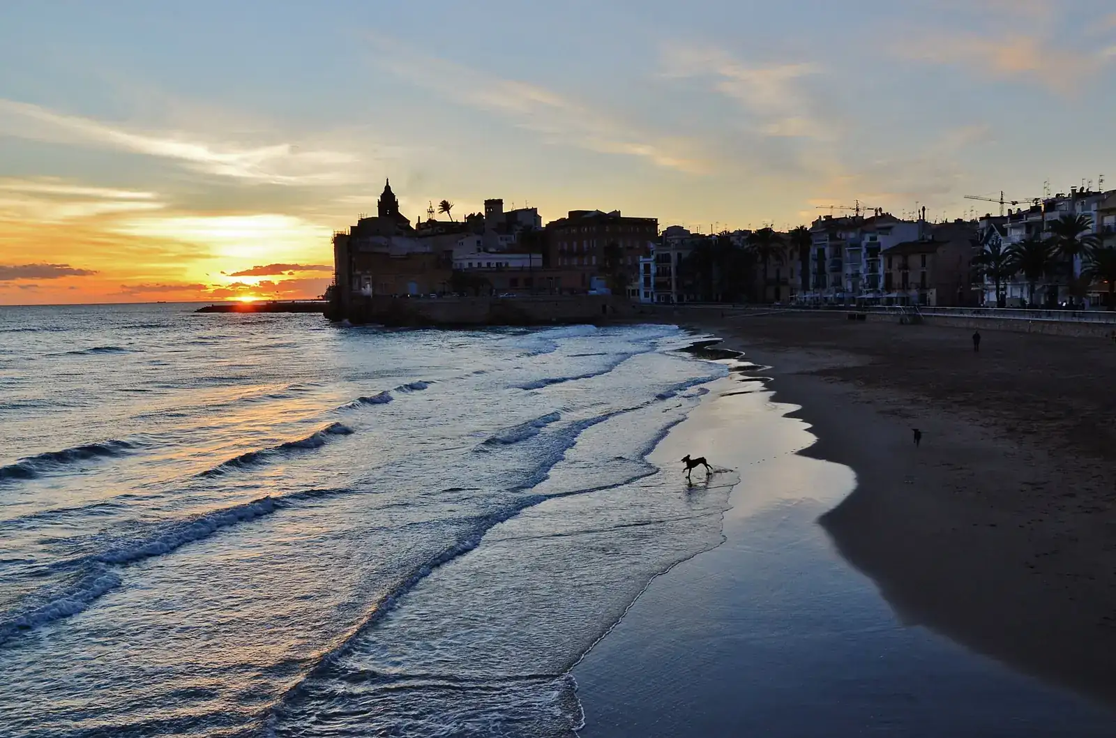 Platja de Sant Sebastià i església de Sant Bartomeu i Santa Tecla de Sitges a la posta de sol